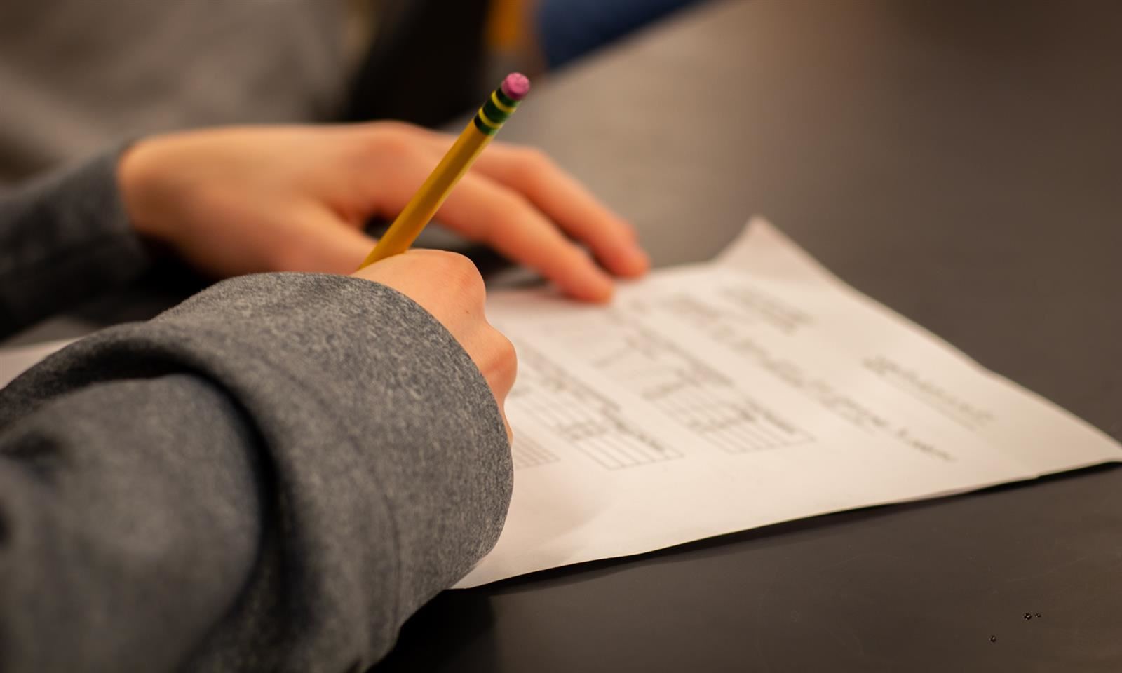 Picture of student's hand writing with pencil 